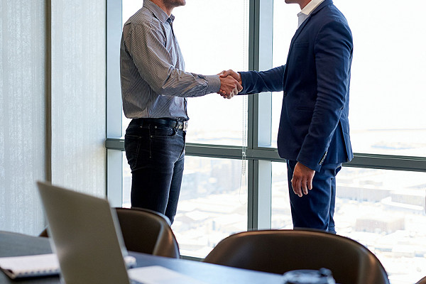 two men shaking hands in a meeting