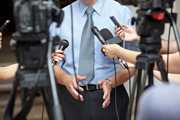 man being interviewed by reporters