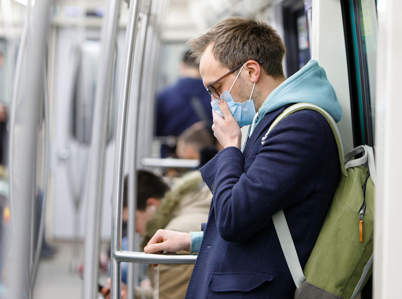 Young man an on a London tube wearing a mask to protect him from coronavirus